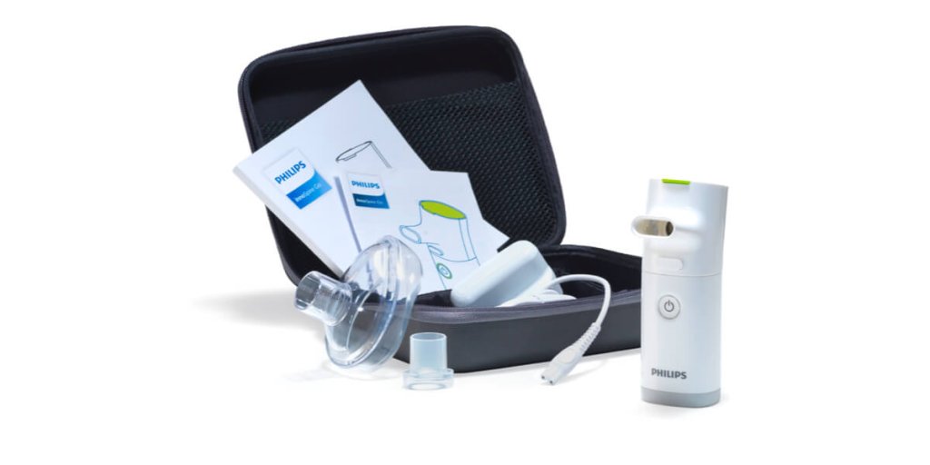 Ein tragbares Philips Vernebler-Kit, ein zuverl&auml;ssiger Sanit&auml;tsartikel, enth&auml;lt Gebrauchsanweisungen, Maske, Mundst&uuml;ck und Netzkabel, ordentlich angeordnet neben einer schwarzen Tragetasche mit Rei&szlig;verschluss.