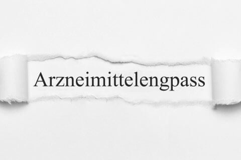 Das Wort Arzneimittelengpass steht zentriert auf weissem Grund, der durch einen horizontalen Riss im Papier sichtbar wird - ein Hinweis auf die Ausgabe des Medikamentenengpasses in der Schweiz.