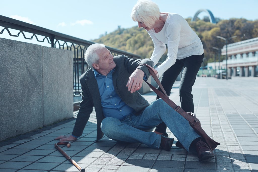 Thoughtful woman helping mature stranger to stand up